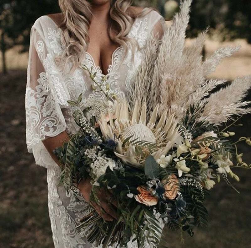 ramo de novia con proteas y plumazos